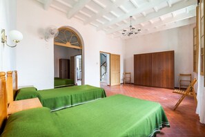 Une chambre avec deux lits, une armoire en bois et une chaise.