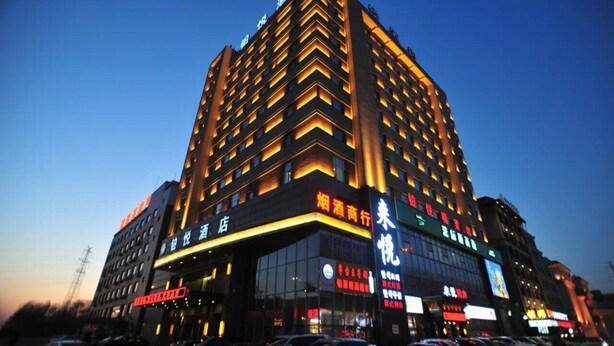 A multi-story hotel with illuminated signage and a modern architectural design. - Boyue Hotel (Changchun)