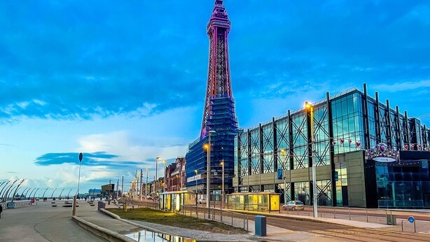 Un bâtiment moderne doté d’une façade en verre et d’une tour imposante.