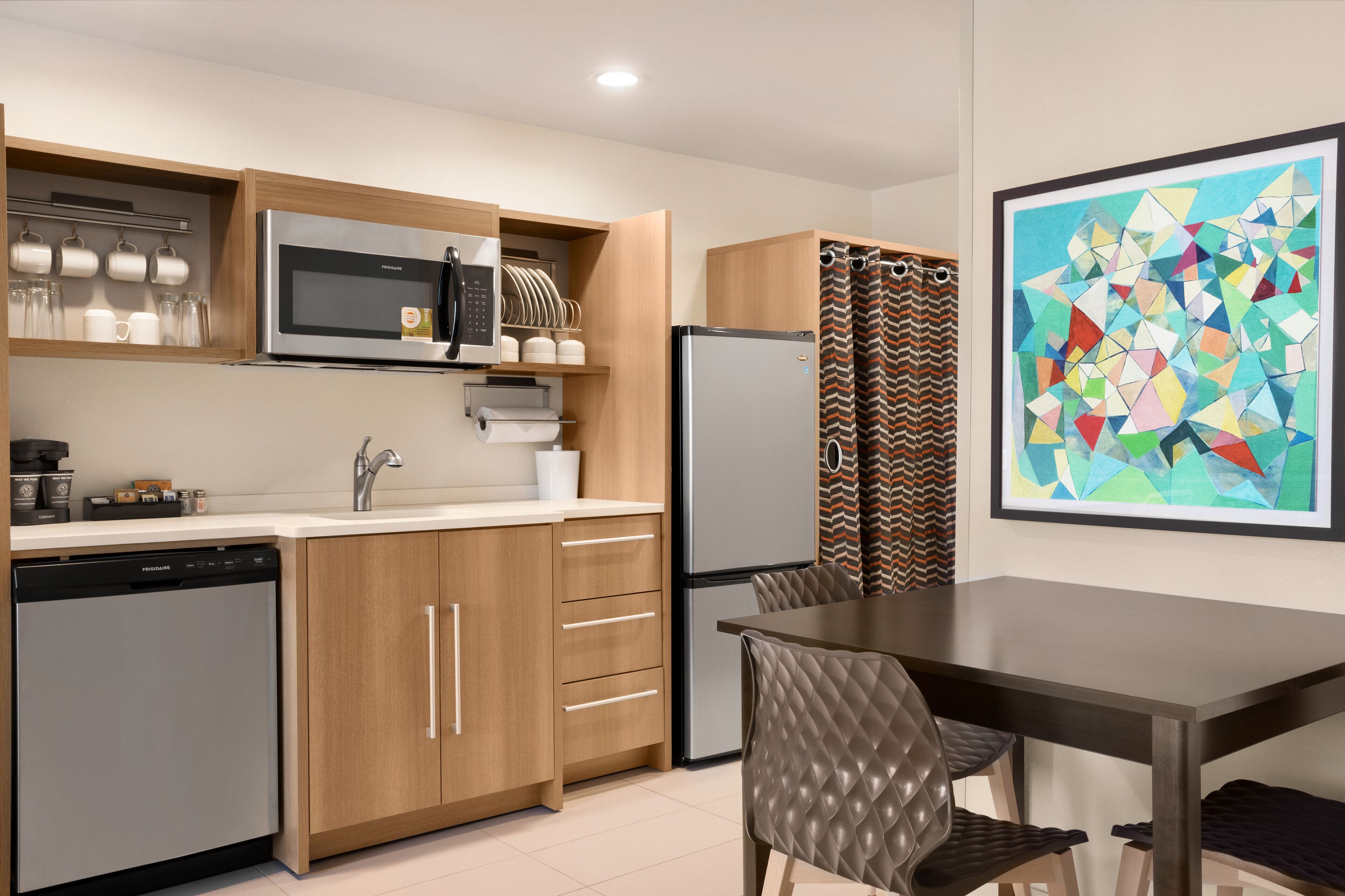 A compact kitchen with a microwave, refrigerator, and dishwasher.