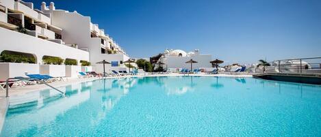 Una piscina al aire libre, una piscina climatizada