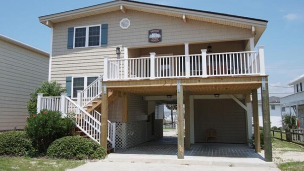 A two-story building with a covered porch and a staircase leading to the upper level. - Nautical Winds, Beach House in Cherry Grove, Just Steps From the Beach (North Myrtle Beach)