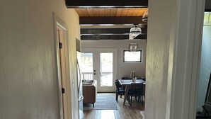Ein Flur mit Holzboden, der zu einem Essbereich mit Tisch und Stühlen führt.