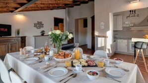 Un comedor con una mesa preparada para el desayuno, una cocina al fondo y un letrero que dice 'just eat it'.