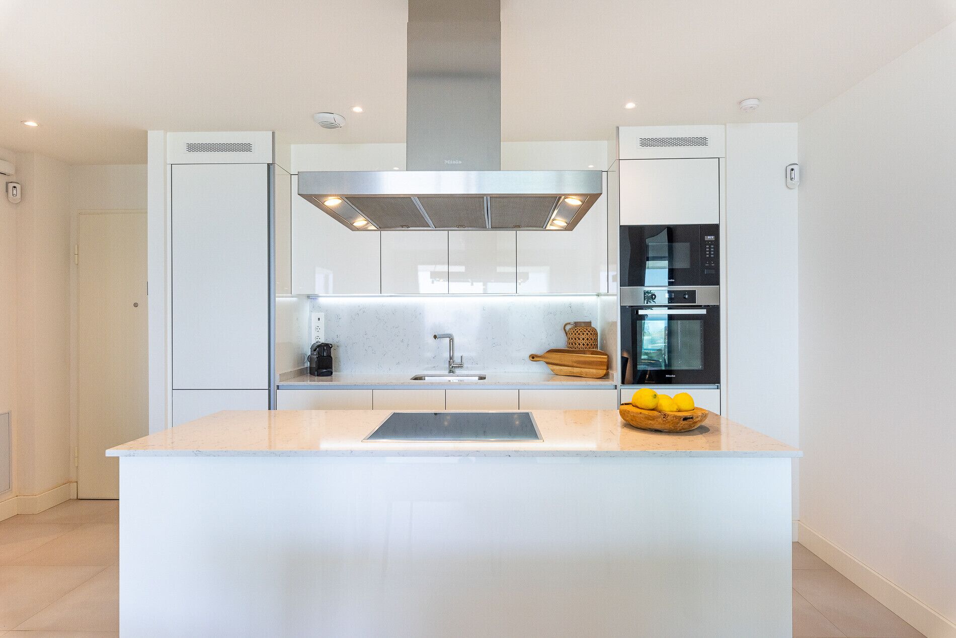 Una cocina moderna con una isla central, electrodomésticos de acero inoxidable y un diseño elegante.