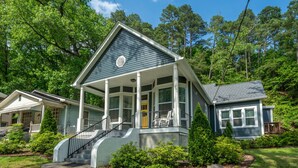 A two-story house with a porch, a front staircase, and a well-maintained lawn. - Pet friendly 5 minute walk to Bath House! (Hot Springs)