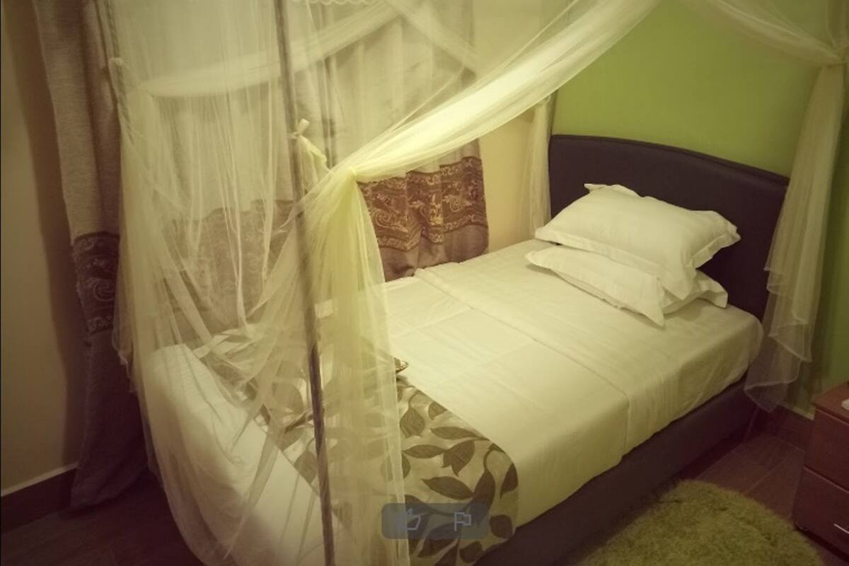 A bed with a canopy, a pillow, and a nightstand.