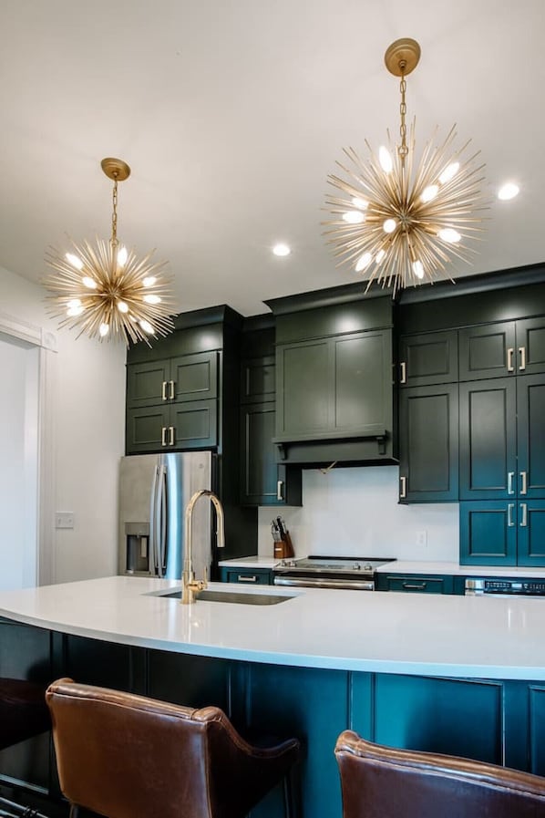 Enjoy cooking in this well-equipped kitchen with a central island, oven, and stainless steel appliances.