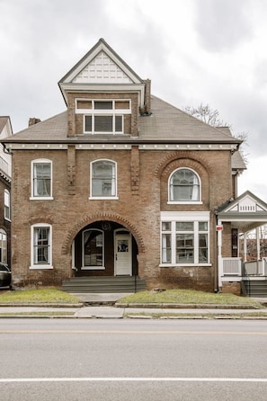 Stunning two-story building with a central entrance and arched doorway, set amidst a charming street scene.