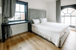 Relax in this serene bedroom with a large bed, flanked by a window and a bench.