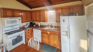 A kitchen with wooden cabinets, a stove, a microwave, a dishwasher, and a refrigerator.