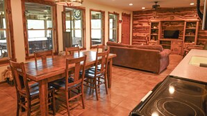 A spacious kitchen with a dining table, chairs, and a built-in oven.