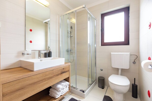A modern bathroom with a glass-enclosed shower, a white sink, and a toilet. - Apartment Morgan 3 with 15m2 Terrace (Poreč)