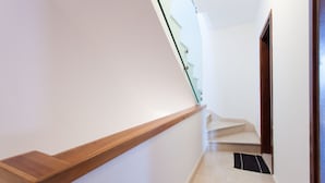 Een moderne trap met een houten leuning en een glazen balustrade.