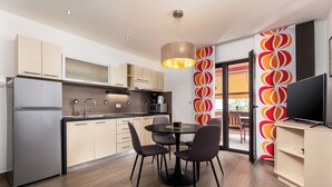 Een moderne keuken met een eethoek, een flatscreen televisie en een groot raam.