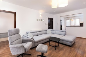 A modern living room with a grey sectional sofa, a black coffee table, and a grey armchair. - Apartment Mares Family 5+ 100m2 with parking and garden (Porec)