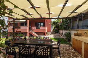 An outdoor patio with a table and chairs, a barbecue grill, and a covered seating area. - Apartment Mares Family 5+ 100m2 with parking and garden (Porec)