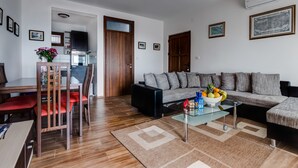 A modern living room with a sofa, coffee table, and dining area. - 3BR Villa w Amazing Hilltop View on Budva Riviera (Lapčići)