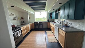 A kitchen with wooden cabinets, a stove, and a window providing natural light.