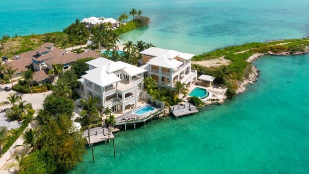A large, multi-story resort with a pool, located on a small island surrounded by turquoise waters. - Oceanfront, Private Dock, Paddle Boards, Feb Pt Access!! (Georgetown, BS)