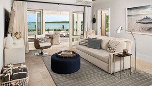 A modern living room with a sofa, ottoman, and chair, a dining table, and a view of the sea. - Oceanfront, Private Dock, Paddle Boards, Feb Pt Access!! (Georgetown, BS)