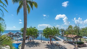 A beachside resort with a pool, palm trees, and a view of the ocean. - Top floor condo in Key Largo with spectacular Sunset views (Key Largo)