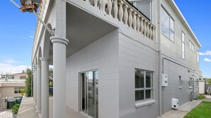 Ein zweigeschossiges Wohngebäude mit Balkon, großen Fenstern und einer Garagentür.