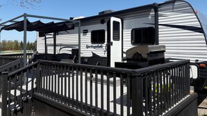 A white RV with 'Springdale' branding parked at a campground.