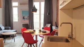 Eine moderne Küche mit Spüle, Esstisch und roten Stühlen.