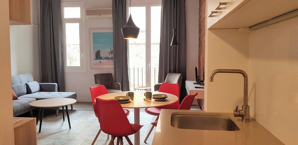 Une cuisine moderne avec un évier, une table à manger et des chaises rouges.