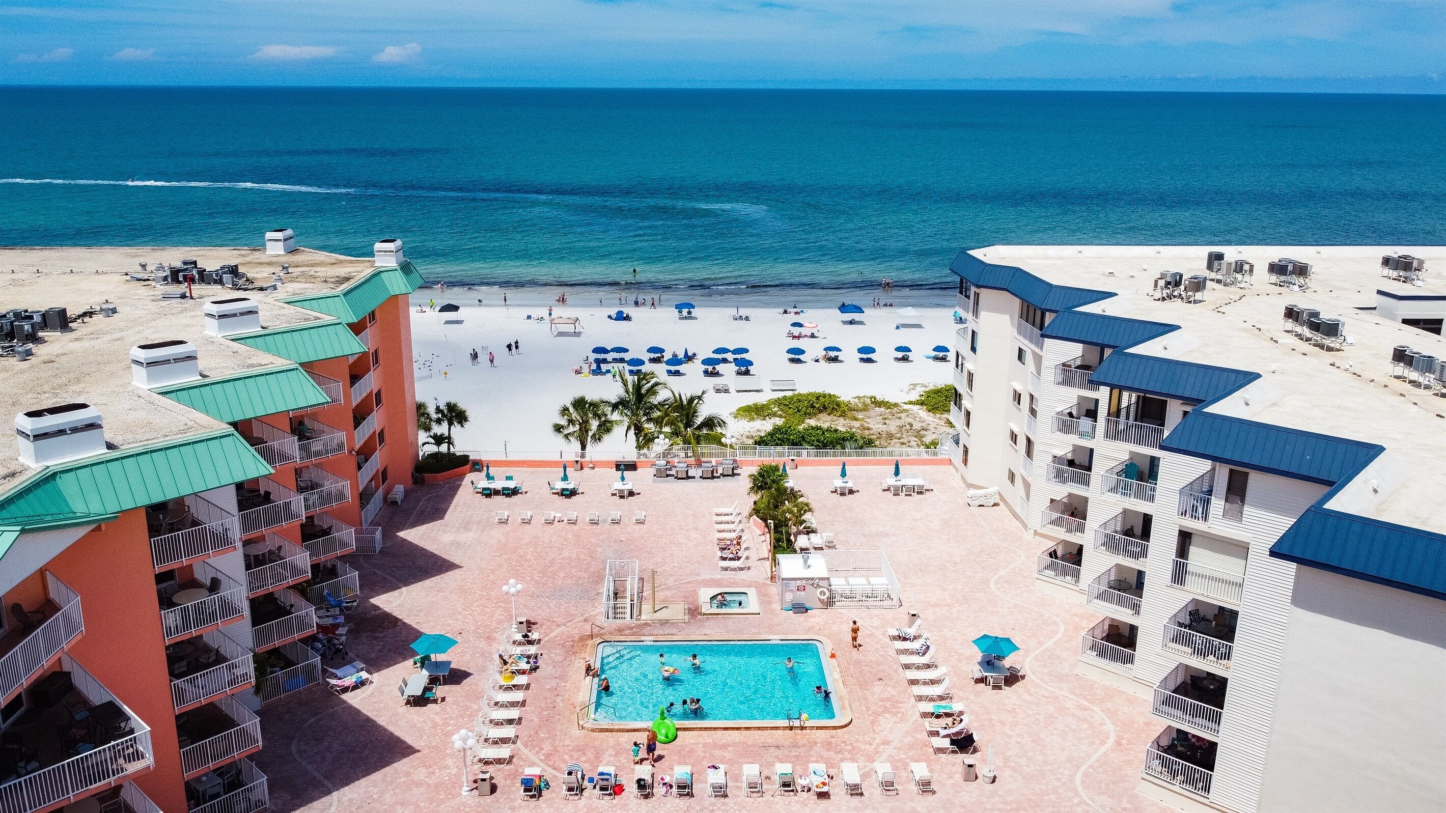 A resort with a pool, beach, and ocean view.