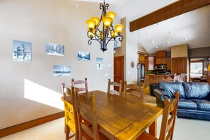 Enjoy meals in this inviting dining area with a wooden table and comfortable seating.
