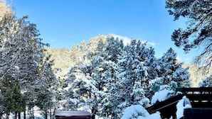 A snow-covered outdoor area with a wooden structure and a large planter filled with snow.