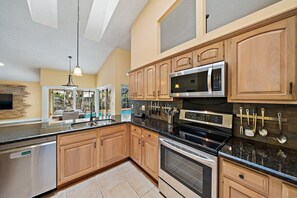 Enjoy cooking in this well-equipped kitchen with a large island, sink, and seating area.