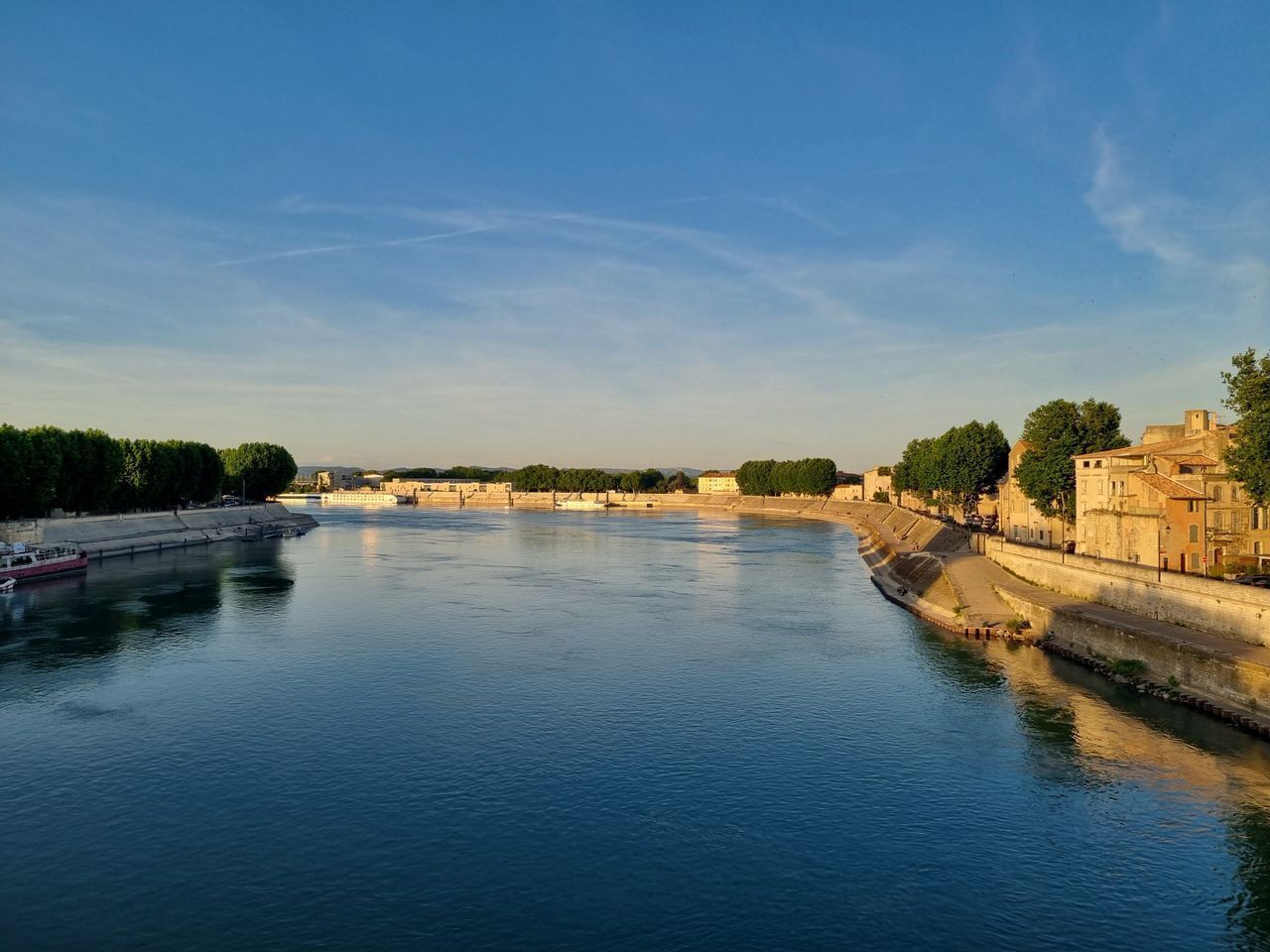 A river with buildings on the right bank and a boat on the left.