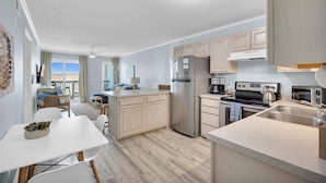 Een moderne keuken met een centraal eiland, inbouwapparatuur en een eethoek met uitzicht.
