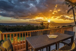 Enjoy the ocean view from this balcony, featuring a wicker table and chairs.