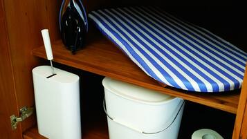 Een houten plank met een blauw-wit geruit kleedje, een witte emmer en een witte, cilindervormige vorm.