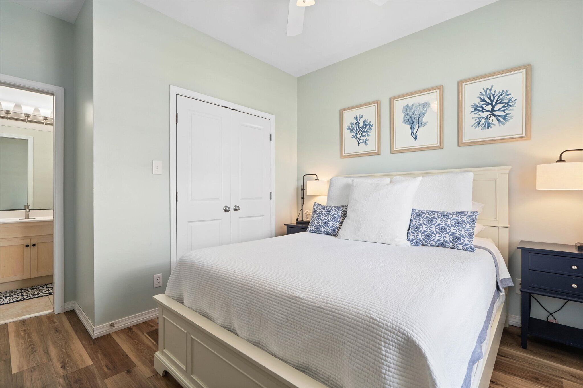 Un dormitorio con cama, mesita de noche, cómoda y puerta.
