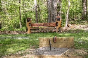 A wooden bench labeled "PONDEROSA" in a forested area with a small wooden structure in front. - Little Joe Log Cabin, UTK/Neyland, Smokies, 16acres, FP, HotTub, Fishing, Pets (Knoxville)