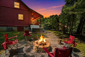 A log cabin with a fire pit and outdoor seating.