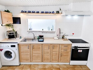 Een koffiezetapparaat/waterkoker, een koelkast, een oven, een kookplaat