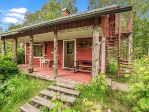 A rustic cabin with a porch, a staircase, and a small table with chairs. - Kesämäki by Interhome (Punkaharju)