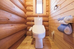 A small, wooden cabin-style bathroom with a toilet, a window, and a towel dispenser. - Rental Villa No 818 LDK 18 tatami mats  Western / Yama-gun Fukushima (Yama-gun)