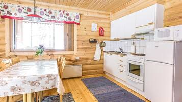 Een koelkast, een magnetron, een vaatwasser, kookgerei, borden en bestek