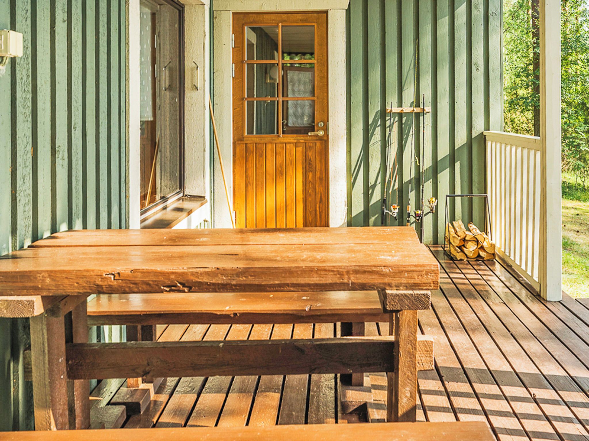 Een houten veranda met een bank en een deur.