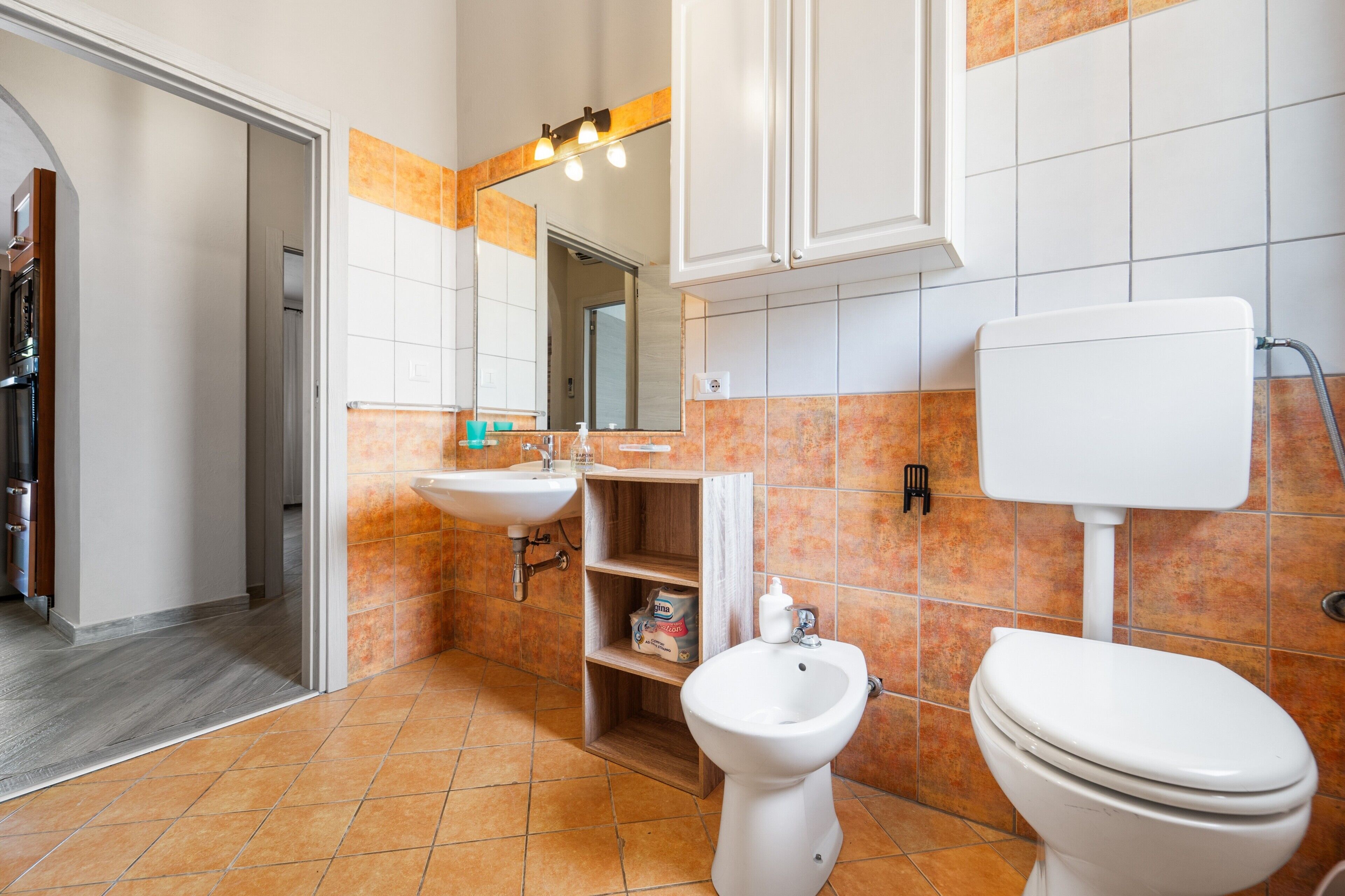 A bathroom with a toilet, sink, and bidet.