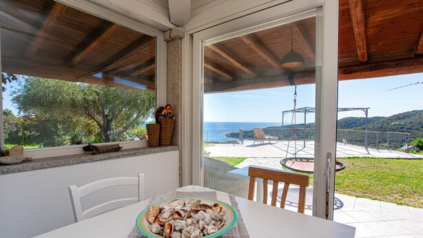 Un patio techado con una mesa, sillas y un tazón de comida.