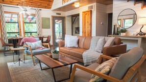 Una sala de estar acogedora con un sofá, sillones, una mesa de centro y un comedor con sillas y una mesa.
