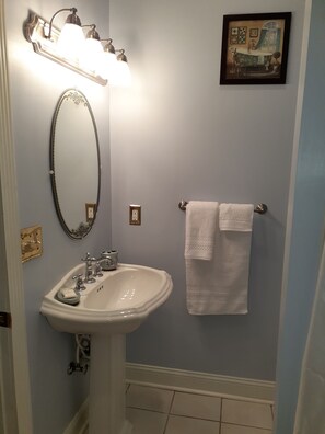 Een bad/douchecombinatie, een haardroger, handdoeken, zeep